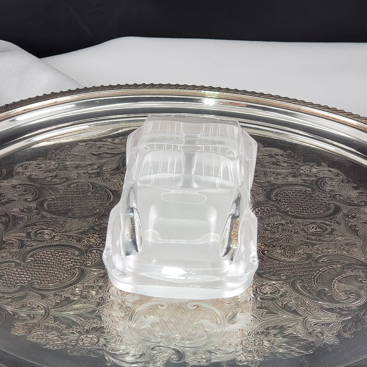 Clear vintage car-shaped glass trinket dish on an ornate silver tray