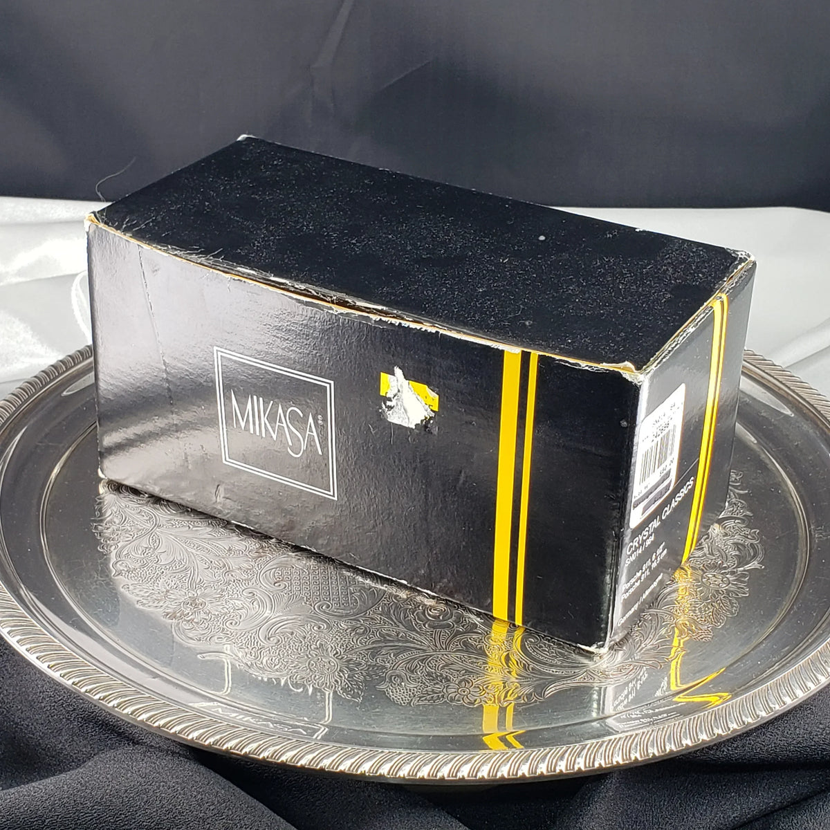 Black Mikasa Crystal Classics box resting on a silver decorative tray
