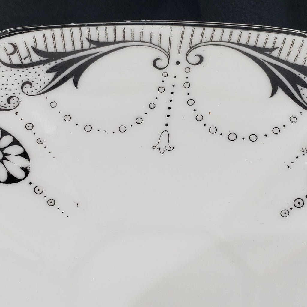a close-up view of a decorative plate with a floral pattern and a small bell-shaped design.