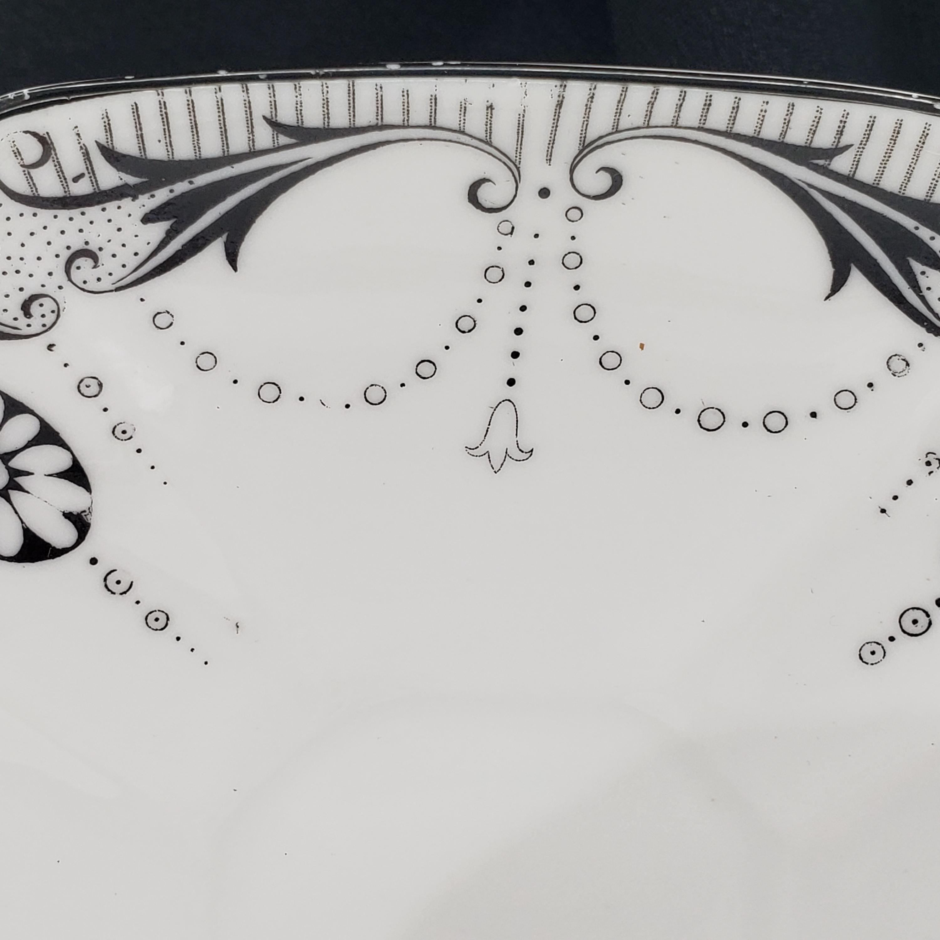 a close-up view of a decorative plate with a floral pattern and a small bell-shaped design.