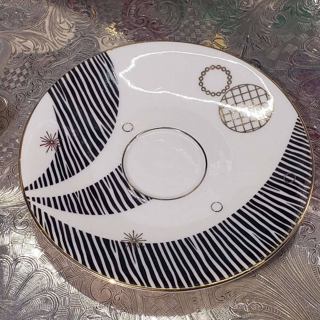 a decorative plate with a black and white striped pattern and a central circular design.