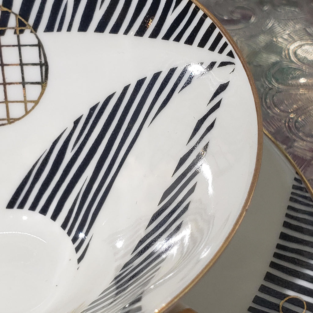 a close-up view of a white bowl with a black and white striped pattern on it.