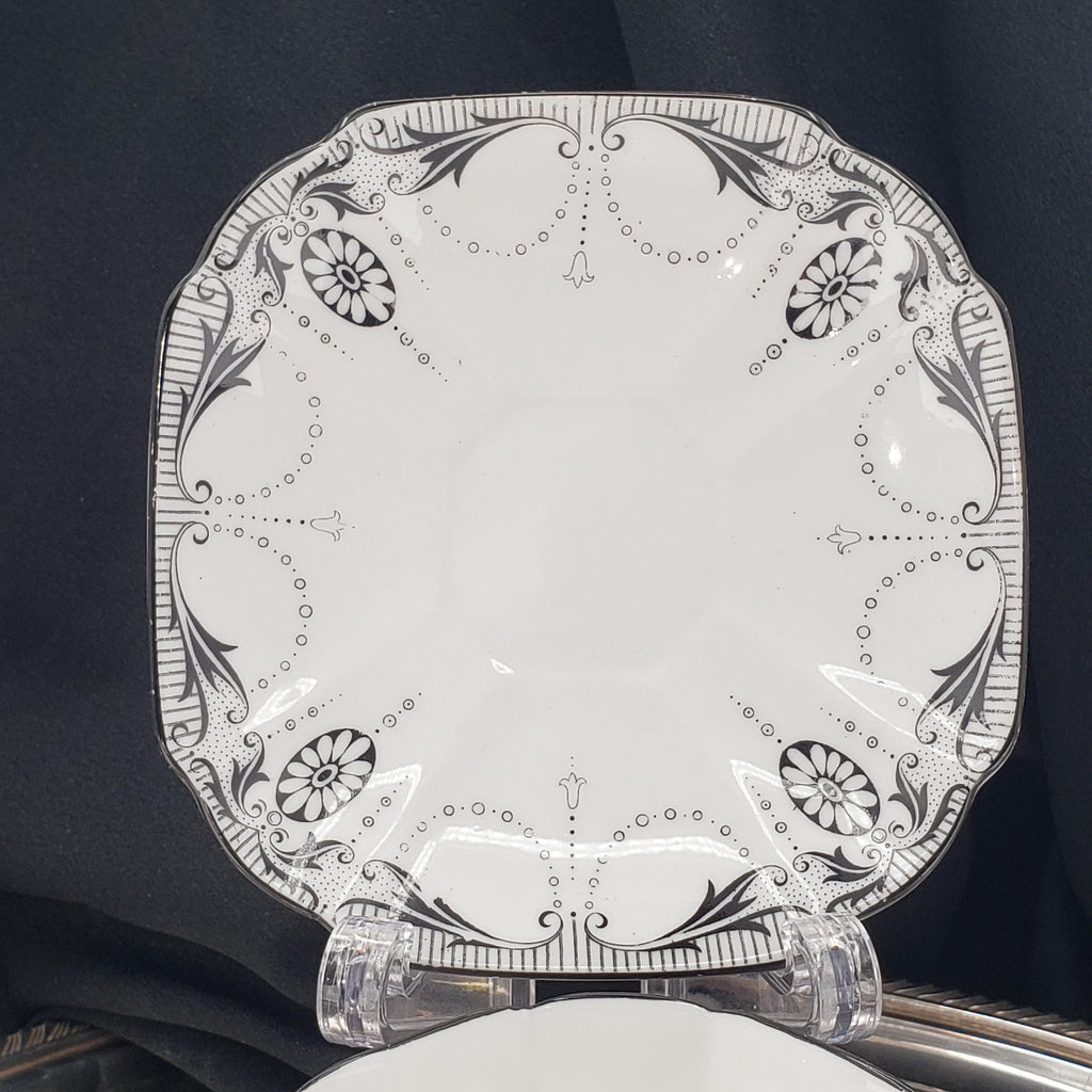 a decorative white plate with a black and white floral pattern.