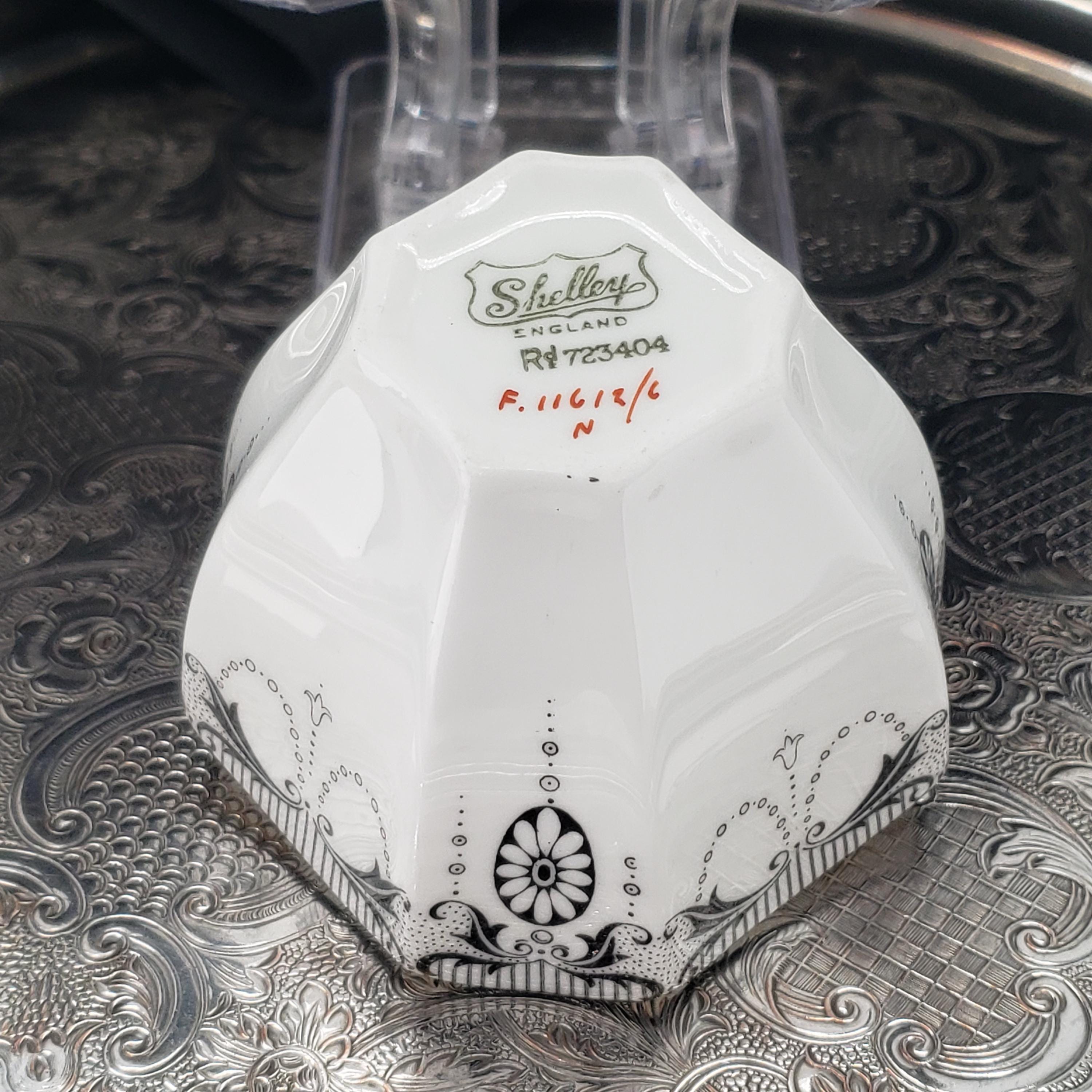A white ceramic bowl with a black and white floral design, sitting on a metal surface.