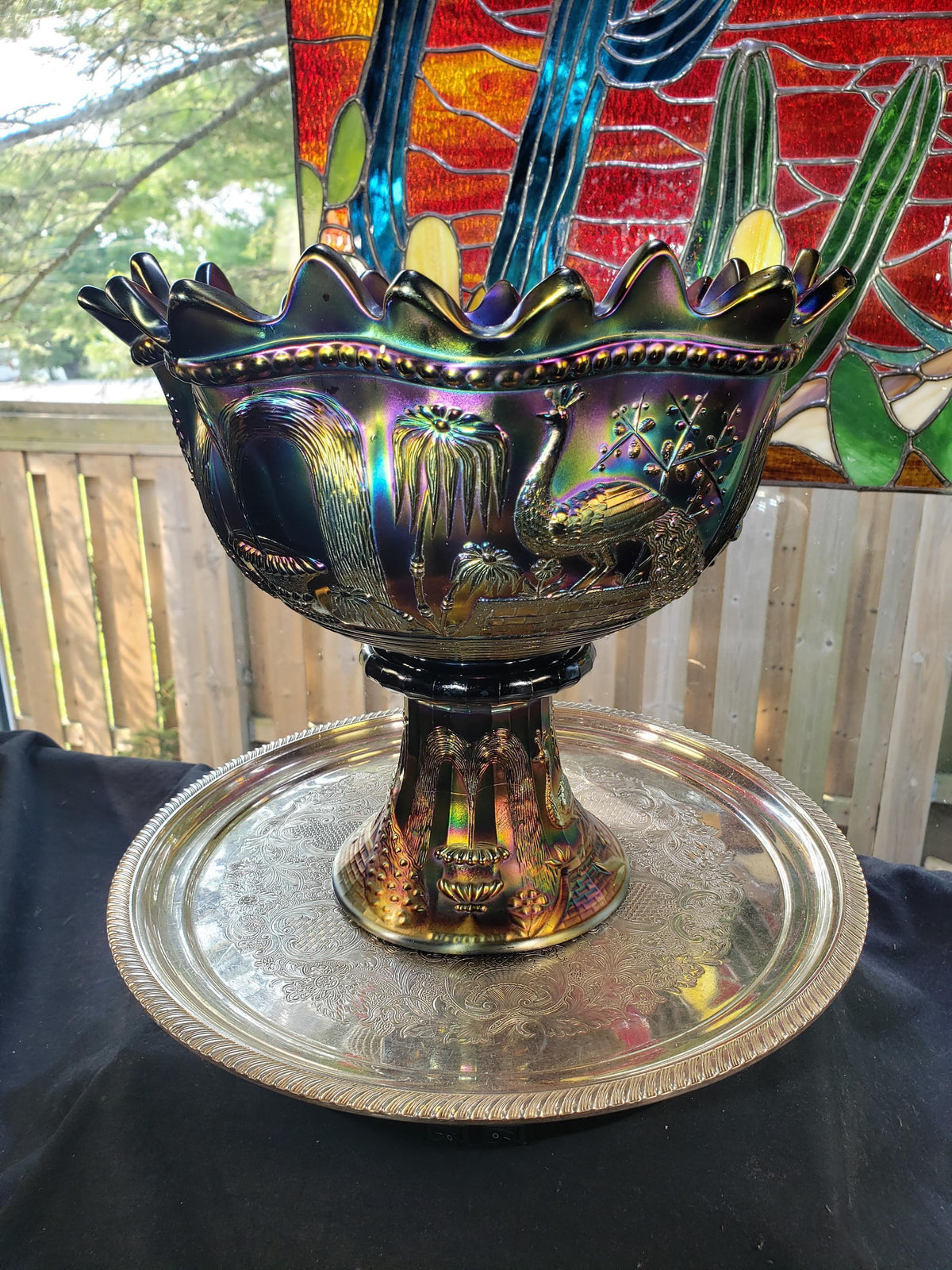 a decorative bowl with intricate designs, placed on a silver tray.