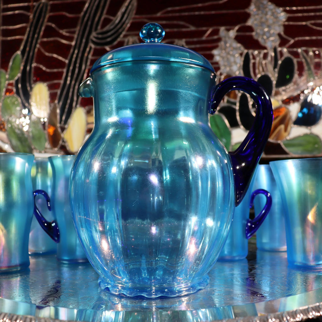 Light blue iridescent Fenton Glass pitcher with two different styles of 4 glasses. Celeste Pattern from the 1920s