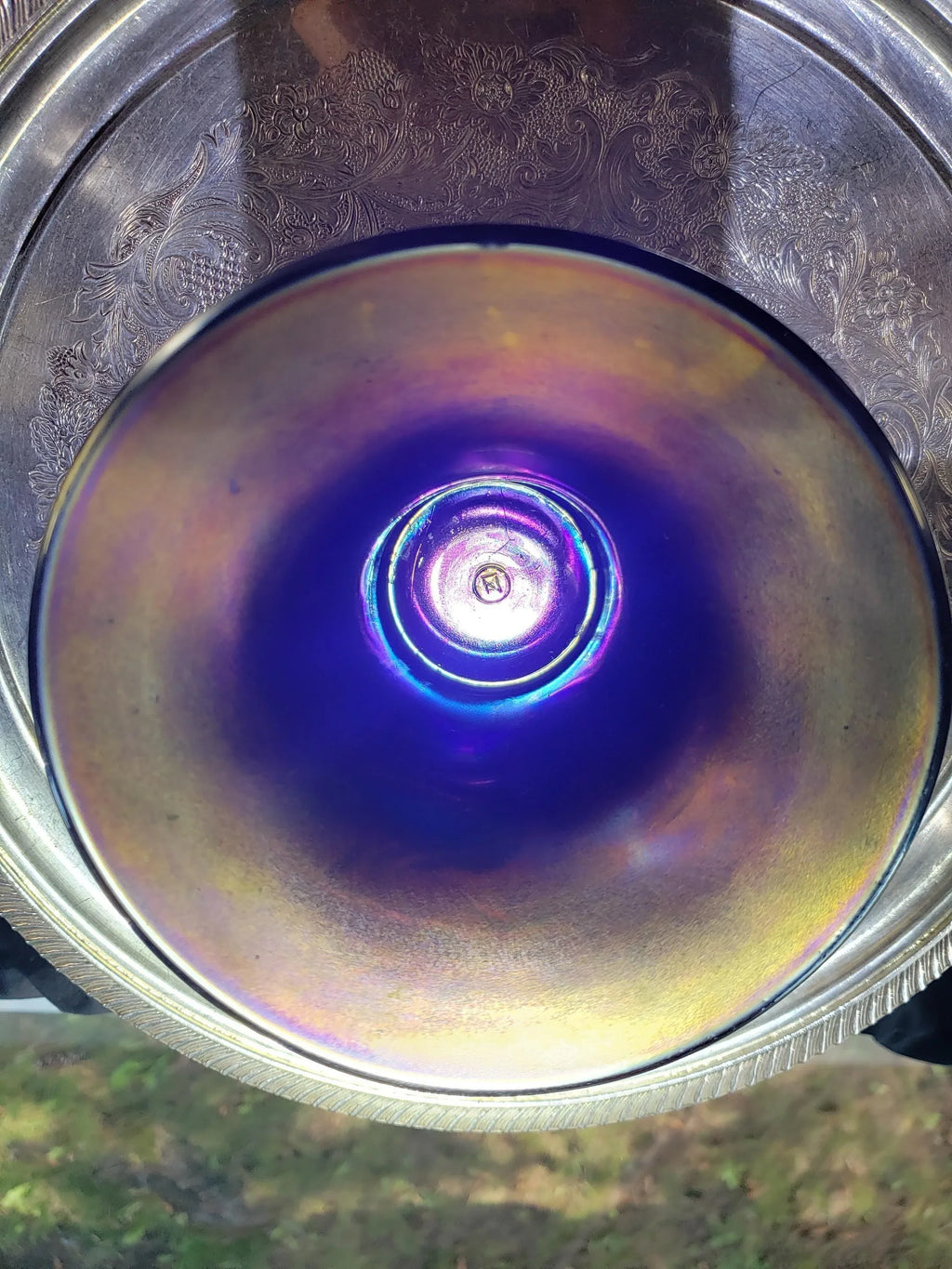 a close-up view of a glass or metal object with a vibrant blue and purple color, possibly reflecting light or creating a colorful effect.